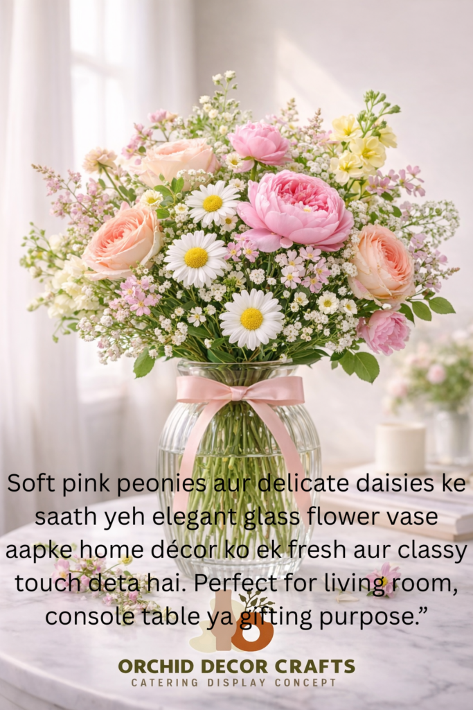 Elegant glass flower vase with pink peonies, peach roses, and white daisies arranged beautifully on a marble table.